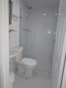 y baño blanco con aseo y ducha. en Hotel Fegali Art Boutique, en Cartagena de Indias