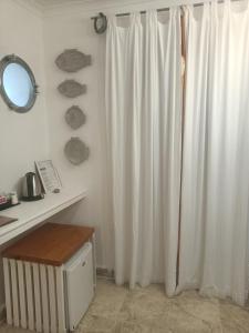 bagno con tenda da doccia bianca e specchio di Piccolo Hotel Luisa a Ponza