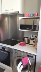 een keuken met een fornuis en een wasmachine bij Villa proche du Stade de France JO 2024 in La Courneuve