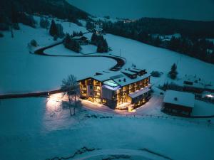 una vista aerea di una casa nella neve di notte di La Cort My Dollhouse - Adults Only a Ortisei