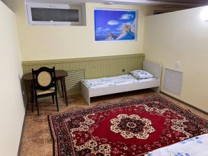 a bedroom with a bed and a rug and a chair at Mang’o Hostel in Aktau