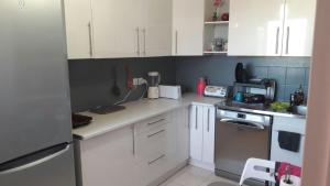 a kitchen with white cabinets and a counter top at Villa proche du Stade de France JO 2024 in La Courneuve