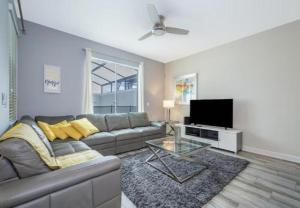 uma sala de estar com um sofá e uma televisão de ecrã plano em Stunning Townhouses 5 Minutes away Disney! em Kissimmee