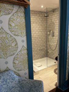 a bathroom with a shower and a glass shower stall at The Swan Inn in Shipton under Wychwood