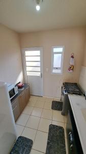 a small kitchen with a stove and a window at Casa Confortável Mobiliada in Marília