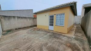 a small house with a door in a yard at Casa Confortável Mobiliada in Marília