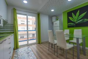 una cucina con pareti verdi e tavolo e sedie di 085 - Gaviotas 005 - comfortHOLIDAYS a Santa Pola Altre 14 foto