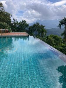uma grande piscina com uma montanha ao fundo em Homestay Namaha em Meppādi