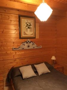 um quarto com uma cama num chalé de madeira em chalet de la haute fontaine em Anould