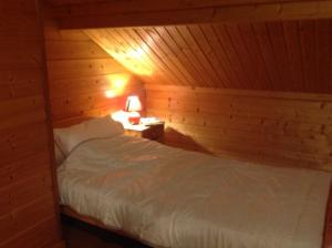 a bedroom with a bed in a wooden cabin at chalet de la haute fontaine in Anould