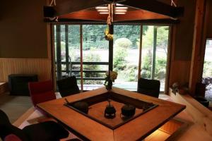 ein Wohnzimmer mit einem Tisch und einem großen Fenster in der Unterkunft 那須リゾートMomiji 貸切 in Nasu