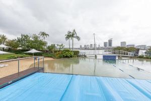 a large swimming pool with a city in the background at Cozy 2BD Apt w Waterview near Olympic Park in Sydney