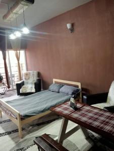 a bedroom with a bed and a table in it at Hostel Praga in Türkistan