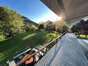 a balcony of a house with a view of a yard at Maso Zambo Resort - Adults only -2 Rooms, Spa & Restaurant sopra il lago di Como in Cassina Valsassina