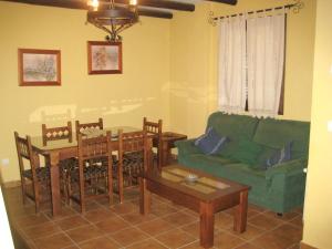 een woonkamer met een groene bank en een tafel bij 3 bedrooms house with shared pool and wifi at Hornachuelos in Hornachuelos