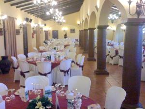 un salón de banquetes con mesas blancas y sillas blancas en 3 bedrooms house with shared pool and wifi at Hornachuelos, en Hornachuelos