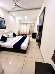 a bedroom with a large bed and a television at JB Residency Zirakpur !! Top Rated & Most Awarded Property in Zirakpur in Zirakpur