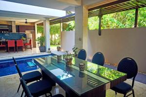 a dining room with a table and chairs and a pool at Indi Villas - The Bhadra Villa in Seminyak