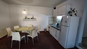 Il comprend une cuisine équipée d'une table et d'un réfrigérateur blanc. dans l'établissement Casa para 6 y 1 garaje - Yerutí, à Posadas