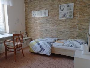 ein Schlafzimmer mit einem Bett, einem Stuhl und einer Ziegelwand in der Unterkunft Apartment Krnov in Krnov