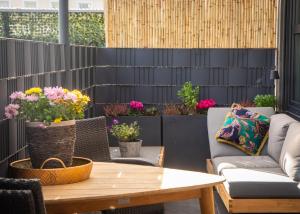 een patio met een tafel, stoelen en bloemen bij Loft Ferienwohnung Lechenich in Erftstadt