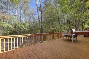 eine Holzterrasse mit einem Tisch und Stühlen darauf in der Unterkunft Rivendell Creekside Cabin in Cosby