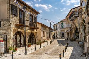 a cobblestone street in an old town with buildings at Lefkara Hotel in Pano Lefkara