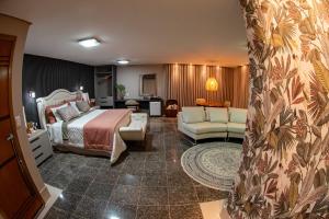 a hotel room with a bed and a living room at Spa Agua Milagrosa in Cuiabá +213 photos