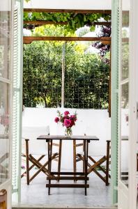 una mesa con un jarrón de flores en un patio en Georgias House en Skyros