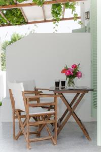 a wooden table and chairs with a vase of flowers at Georgias House in Skiros