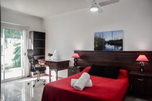 1 dormitorio con cama roja, escritorio y manta roja en Categórica Casa con Cocina Premium 3 Habitaciones en Centro de Paraná en Paraná