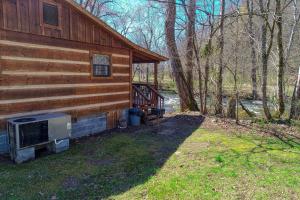 a log cabin with a staircase next to a house at Creekside Memories Cabin in Cosby