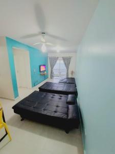 a room with three beds and a blue wall at Ap frente para o mar in Caraguatatuba