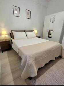 um quarto com uma grande cama branca num quarto em Center River Apartment em Florina