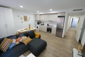 uma sala de estar com um sofá e uma cozinha em 2B PlusUltra piso de 1 dorm em Alicante