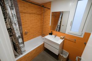 uma casa de banho com uma banheira, um lavatório e um espelho. em 2B PlusUltra piso de 1 dorm em Alicante