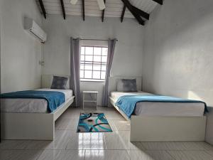 a bedroom with two beds and a window at Bay View Apartments Canouan Island in Canouan