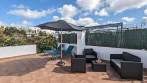 a patio with an umbrella and two chairs and a table at Viva Piso Jerez in Jerez de la Frontera