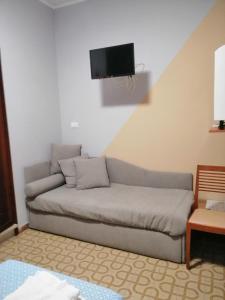 un sofá en la sala de estar con TV en la pared en Cannone d'Oro, en Sale