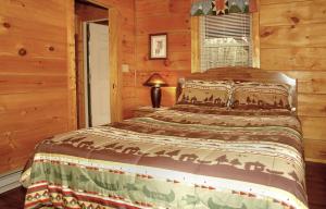 a bedroom with a bed in a log cabin at Jon's Pond in Cosby