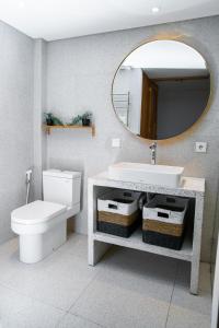 a bathroom with a sink and a toilet and a mirror at KARRA LOFT - Bali Invest Villas in Canggu