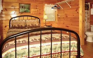 a bedroom with a bed in a log cabin at Jon's Pond in Cosby