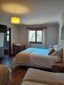 a hotel room with two beds and a window at Hotel Las Cascadas in La Cumbrecita