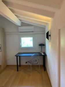 einen Schreibtisch mit Stuhl in einem Zimmer mit Fenster in der Unterkunft PROVENCE facile in Le Tholonet