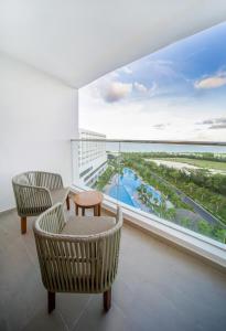 d'un balcon avec des chaises et une table offrant une vue sur l'océan. dans l'établissement Selectum Noa Resort Cam Ranh, à Cam Ranh