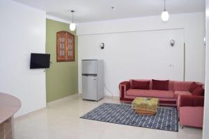 ein Wohnzimmer mit einem Sofa und einem Kühlschrank in der Unterkunft El hady apartments in Luxor