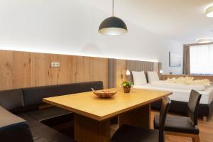 een woonkamer met een tafel en een bed bij Appartement Krippenstein mit Indoorpool und Sauna in Bad Goisern