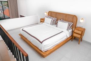 1 dormitorio con 1 cama grande con sábanas y almohadas blancas en KARRA LOFT - Bali Invest Club en Canggu