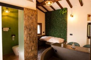 a bathroom with a green wall with a bed at Maison Chanely in Calcata