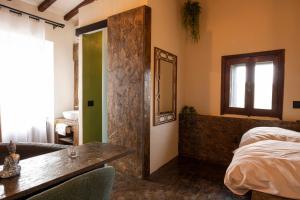 a bedroom with a bed and a table and a window at Maison Chanely in Calcata